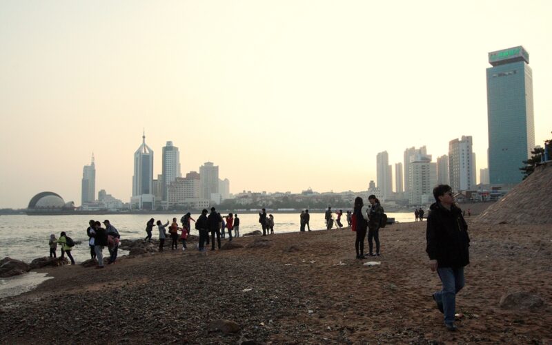 Abendstimmung am Stadtstrand von Qingdao. Zum Baden macht er nicht so an, für einen gemütlichen Spaziergang mit Blick auf die Skyline aber schon.